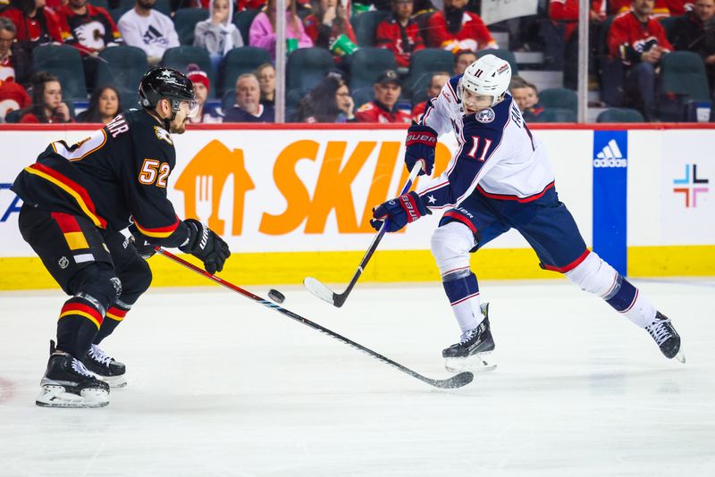 Jan 25, 2024; Calgary, Alberta, CAN; Columbus Blue Jackets center Adam Fantilli (11) shoots the puck against Calgary Flames defenseman MacKenzie Weegar (52) during the first period at Scotiabank Saddledome. Mandatory Credit: Sergei Belski-USA TODAY Sports