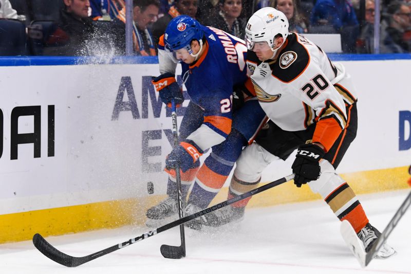 Dec 13, 2023; Elmont, New York, USA; Anaheim Ducks right wing Brett Leason (20) and New York Islanders defenseman Alexander Romanov (28) battle for the puck along the boards during the third period at UBS Arena. Mandatory Credit: Dennis Schneidler-USA TODAY Sports