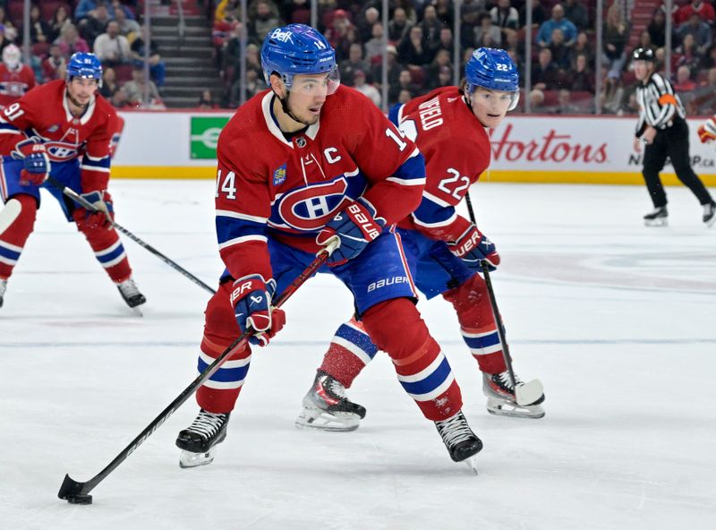 Nov 14, 2023; Montreal, Quebec, CAN; Montreal Canadiens forward Nick Suzuki (14) brings the puck in the Calgary Flames zone with the help of teammate forward Cole Caufield (22) during the third period at the Bell Centre. Mandatory Credit: Eric Bolte-USA TODAY Sports