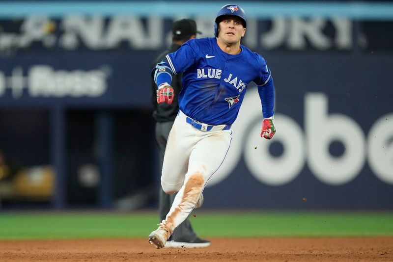 May 22, 2025; Toronto, Ontario, CAN; Toronto Blue Jays center fielder Dalton Varsho (5) runs to third base on his RBI triple against the San Diego Padres during the eleventh inning at Rogers Centre. Mandatory Credit: John E. Sokolowski-Imagn Images