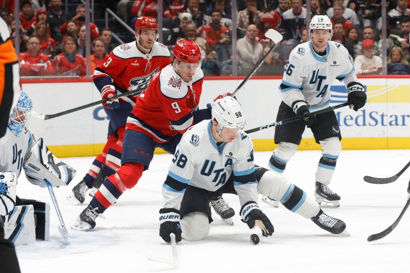 Mar 3, 2026; Washington, District of Columbia, USA; Utah Mammoth defenseman Mikhail Sergachev (98) battles for the puck with Washington Capitals right wing Ryan Leonard (9) during the third period at Capital One Arena. Mandatory Credit: Amber Searls-Imagn Images