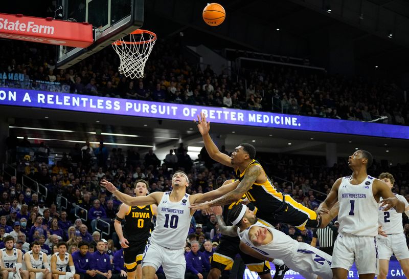 Feb 19, 2023; Evanston, Illinois, USA; Iowa Hawkeyes guard Tony Perkins (11) charges into Northwestern Wildcats guard Boo Buie (0) during the first half at Welsh-Ryan Arena. Mandatory Credit: David Banks-USA TODAY Sports