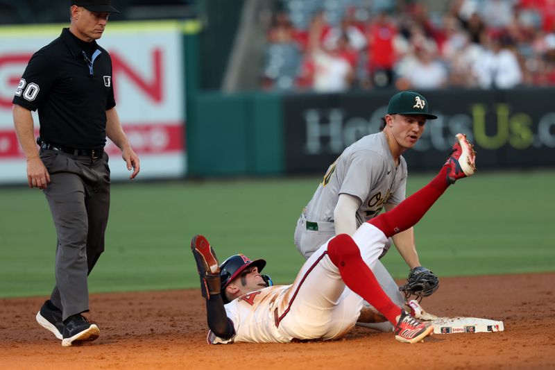 Jul 25, 2024; Anaheim, California, USA;  Los Angeles Angels shortstop Zach Neto (9) is safe at the second ahead of a tag from Oakland Athletics second baseman Zack Gelof (20)during the second inning at Angel Stadium. Mandatory Credit: Kiyoshi Mio-USA TODAY Sports