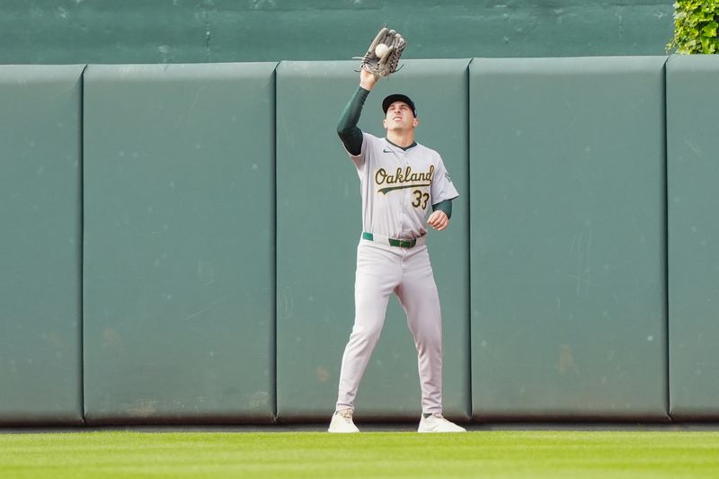 Apr 27, 2024; Baltimore, Maryland, USA; Oakland Athletics center fielder JJ Bleday (33) catches a fly ball hit by Baltimore Orioles center fielder Cedric Mullins (not pictured) during the sixth inning at Oriole Park at Camden Yards. Mandatory Credit: Gregory Fisher-USA TODAY Sports