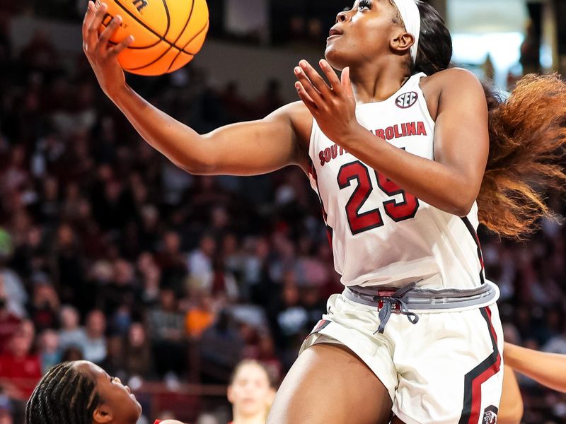 Feb 26, 2023; Columbia, South Carolina, USA; South Carolina Gamecocks guard Raven Johnson (25) drives into Georgia Lady Bulldogs guard De'Mauri Flournoy (10) in the first half at Colonial Life Arena. Mandatory Credit: Jeff Blake-USA TODAY Sports