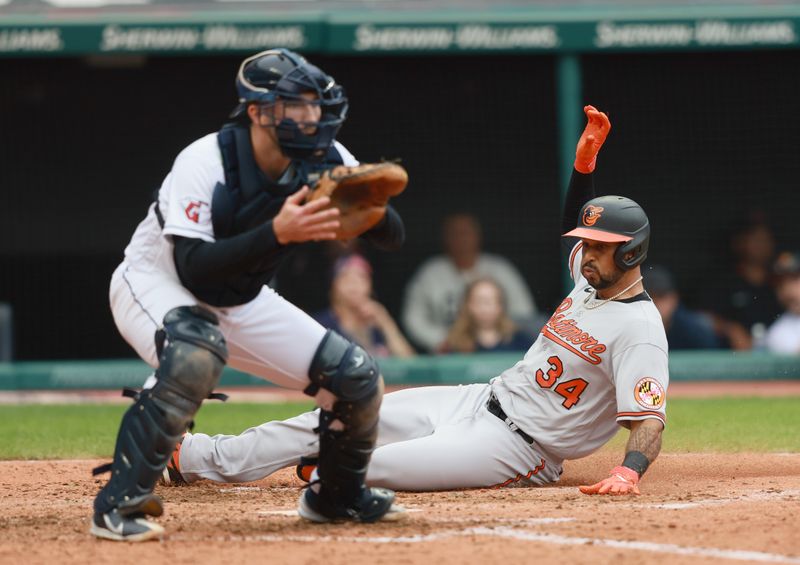 Sep 24, 2023; Cleveland, Ohio, USA; Baltimore Orioles Aaron Hicks (34) slides into home plate safe ahead of the throw to Cleveland Guardians catcher David Fry (12) during the fifth inning at Progressive Field. Mandatory Credit: Aaron Josefczyk-USA TODAY Sports