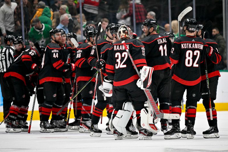 Jan 25, 2023; Dallas, Texas, USA; Carolina Hurricanes goaltender Antti Raanta (32) and the Hurricanes team celebrate the win over the Dallas Stars during the overtime period at the American Airlines Center. Mandatory Credit: Jerome Miron-USA TODAY Sports