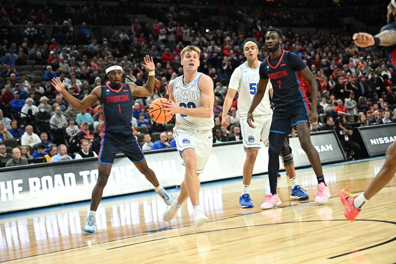 Mar 21, 2024; Omaha, NE, USA; Brigham Young Cougars guard Dallin Hall (30) drives past Duquesne Dukes forward David Dixon (2) in the second half during the first round of the NCAA Tournament at CHI Health Center Omaha. Mandatory Credit: Steven Branscombe-USA TODAY Sports