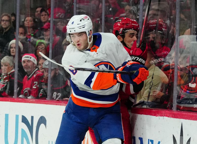 Dec 23, 2023; Raleigh, North Carolina, USA; New York Islanders defenseman Noah Dobson (8) checks Carolina Hurricanes center Seth Jarvis (24) during the first period at PNC Arena. Mandatory Credit: James Guillory-USA TODAY Sports