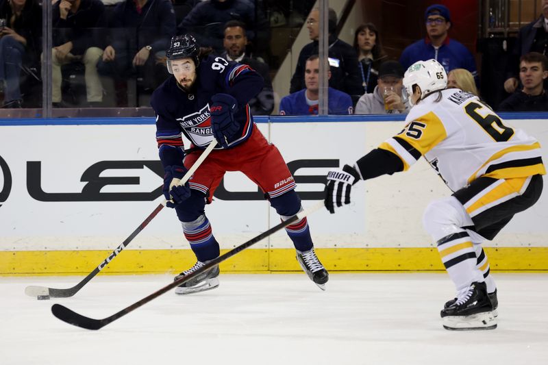 Dec 6, 2024; New York, New York, USA; New York Rangers center Mika Zibanejad (93) plays the puck against Pittsburgh Penguins defenseman Erik Karlsson (65) during the first period at Madison Square Garden. Mandatory Credit: Brad Penner-Imagn Images