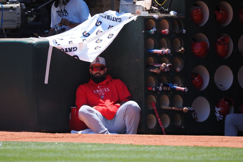 Jul 4, 2024; Oakland, California, USA; Los Angeles Angels  Luis Guillorme (15) under a shade structure made from a gatorade towel in the dugout during the first inning against the Oakland Athletics at Oakland-Alameda County Coliseum. Mandatory Credit: Kelley L Cox-USA TODAY Sports