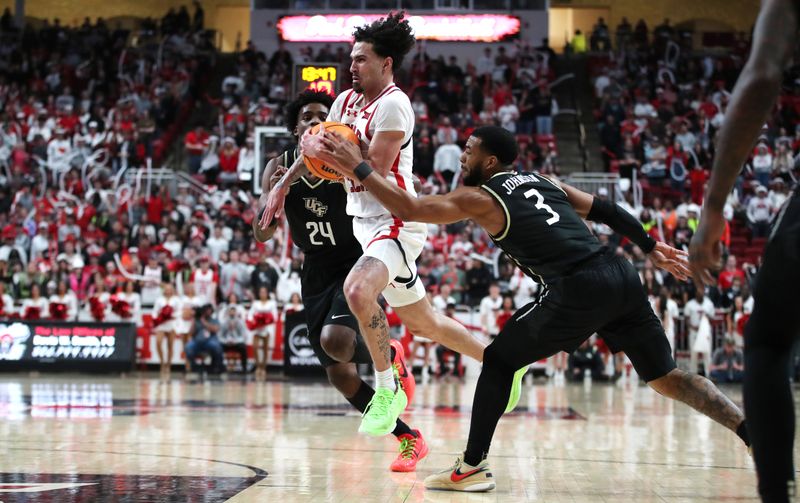 Feb 10, 2024; Lubbock, Texas, USA; Texas Tech Red Raiders guard Pop Isaacs (2) drives between Central Florida Knights guards Jaylin Sellers (24) and Darius Johnson (3) in the second half at United Supermarkets Arena. Mandatory Credit: Michael C. Johnson-USA TODAY Sports