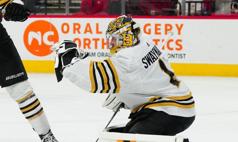 Apr 4, 2024; Raleigh, North Carolina, USA; Boston Bruins goaltender Jeremy Swayman (1) makes a glove save against the Carolina Hurricanes during the first period at PNC Arena. Mandatory Credit: James Guillory-USA TODAY Sports