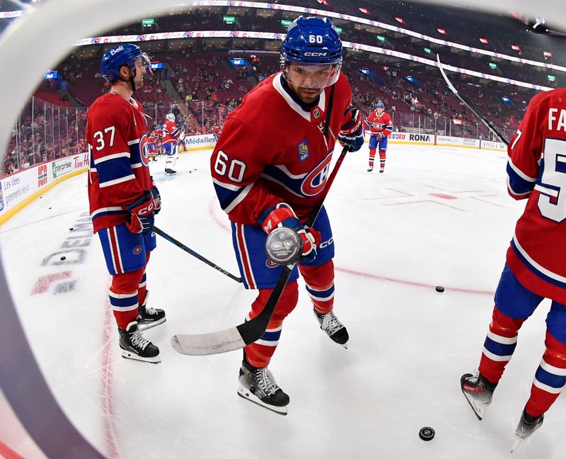 Sep 22, 2025; Montreal, Quebec, CAN; Montreal Canadiens forward Alex Belzile (60) juggles a puck during the warmup period before the game against the Pittsburgh Penguins at the Bell Centre. Mandatory Credit: Eric Bolte-Imagn Images