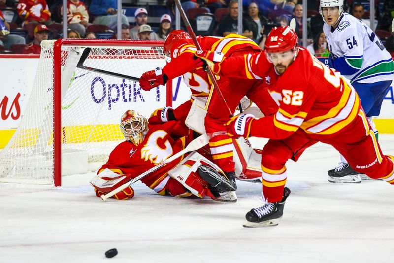 Sep 28, 2024; Calgary, Alberta, CAN; Calgary Flames goaltender Devin Cooley (1) and defenseman Daniil Miromanov (62) collides during the third period against the Vancouver Canucks at Scotiabank Saddledome. Mandatory Credit: Sergei Belski-Imagn Images