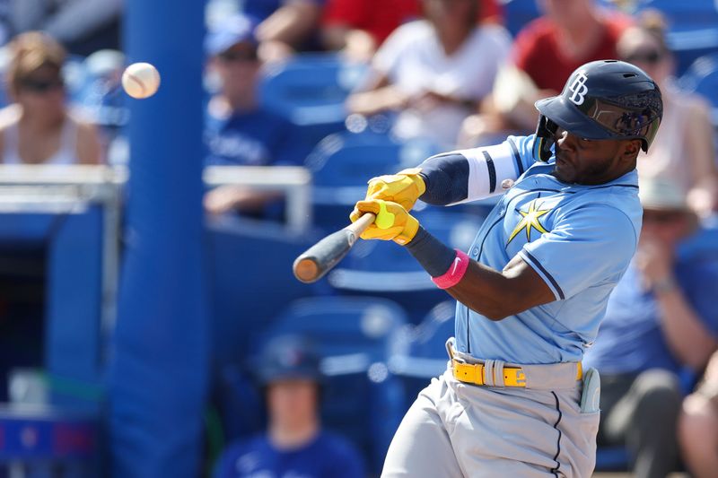 Feb 28, 2024; Dunedin, Florida, USA;  Tampa Bay Rays second baseman Ronny Simon (70) hits a sacrifice fly that scores a run against the Toronto Blue Jays in the fifth inning at TD Ballpark. Mandatory Credit: Nathan Ray Seebeck-USA TODAY Sports