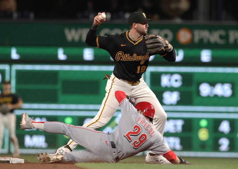 May 20, 2025; Pittsburgh, Pennsylvania, USA; Pittsburgh Pirates second baseman Jared Triolo (19) turns a double play over Cincinnati Reds center fielder TJ Friedl (29) during the ninth inning at PNC Park. Mandatory Credit: Charles LeClaire-Imagn Images