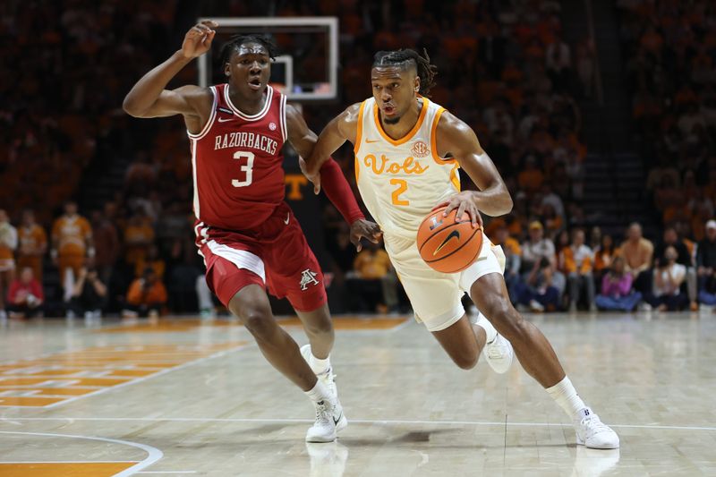 Jan 4, 2025; Knoxville, Tennessee, USA; Tennessee Volunteers guard Chaz Lanier (2) moves the ball against Arkansas Razorbacks forward Adou Thiero (3) during the first half at Thompson-Boling Arena at Food City Center. Mandatory Credit: Randy Sartin-Imagn Images
