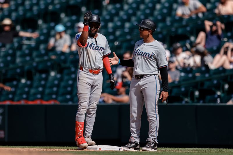 Aug 29, 2024; Denver, Colorado, USA; Miami Marlins shortstop Vidal Brujan (17) reacts from first on an RBI single ahead of first base coach Jon Jay (11) in the sixth inning against the Colorado Rockies at Coors Field. Mandatory Credit: Isaiah J. Downing-USA TODAY Sports