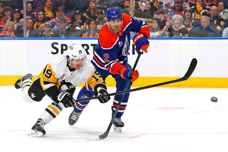 Jan 22, 2026; Edmonton, Alberta, CAN; Pittsburgh Penguins forward Connor Dewer (19) gets a shot away in front of Edmonton Oilers defensemen Evan Bouchard (2) during the second period at Rogers Place. Mandatory Credit: Perry Nelson-Imagn Images