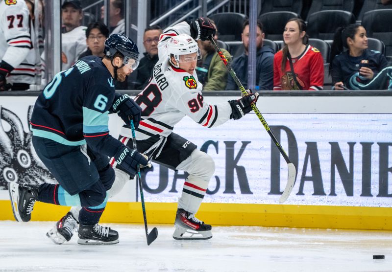 Nov 14, 2024; Seattle, Washington, USA;  Chicago Blackhawks forward Connor Bedard (98) skates against Seattle Kraken defenseman Adam Larsson (6) during the second period at Climate Pledge Arena. Mandatory Credit: Stephen Brashear-Imagn Images