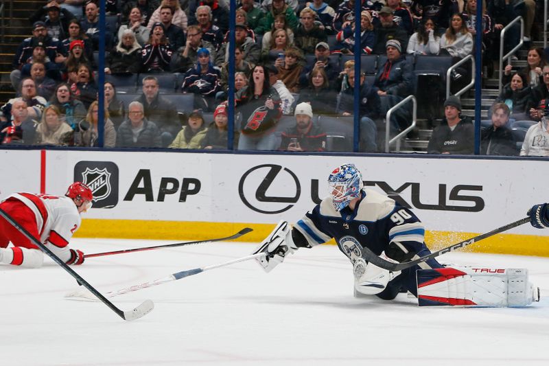 Dec 31, 2024; Columbus, Ohio, USA; Columbus Blue Jackets goalie Elvis Merzlikins (90) sticks away a rebound of a Carolina Hurricanes shot attempt during overtime at Nationwide Arena. Mandatory Credit: Russell LaBounty-Imagn Images