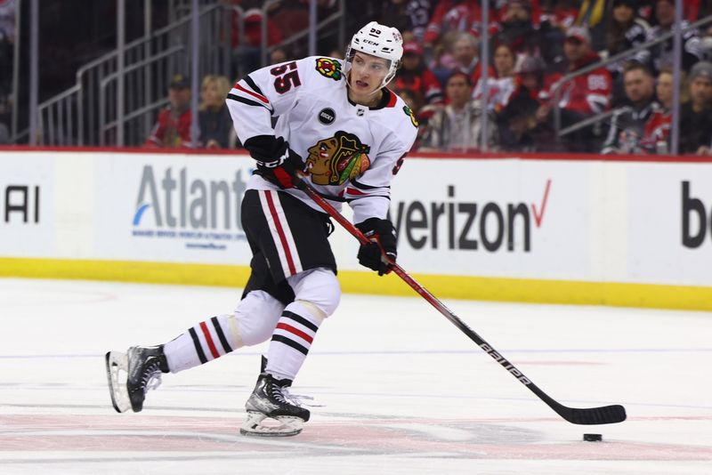 Jan 5, 2024; Newark, New Jersey, USA; Chicago Blackhawks defenseman Kevin Korchinski (55) skates with the puck against the New Jersey Devils during the third period at Prudential Center. Mandatory Credit: Ed Mulholland-USA TODAY Sports