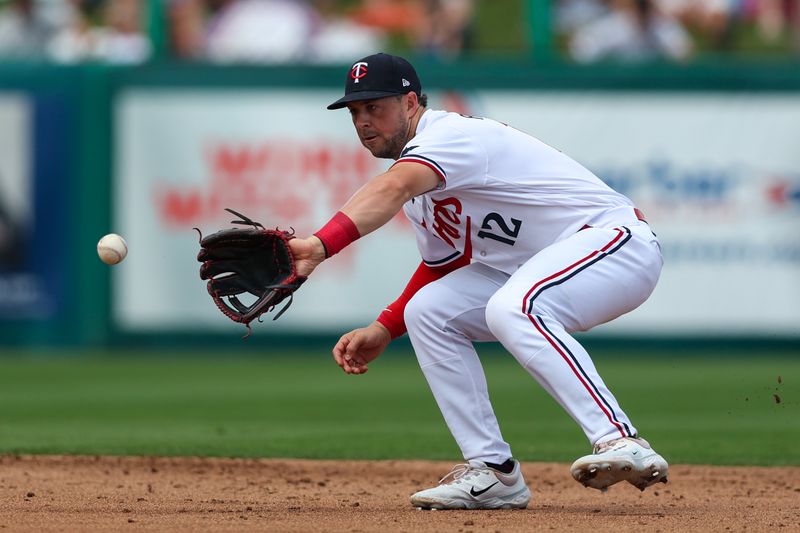 Mar 13, 2023; Fort Myers, Florida, USA;  Minnesota Twins shortstop Kyle Farmer (12) fields the ball fro an out against the New York Yankees in the third inning during spring training at Hammond Stadium. Mandatory Credit: Nathan Ray Seebeck-USA TODAY Sports