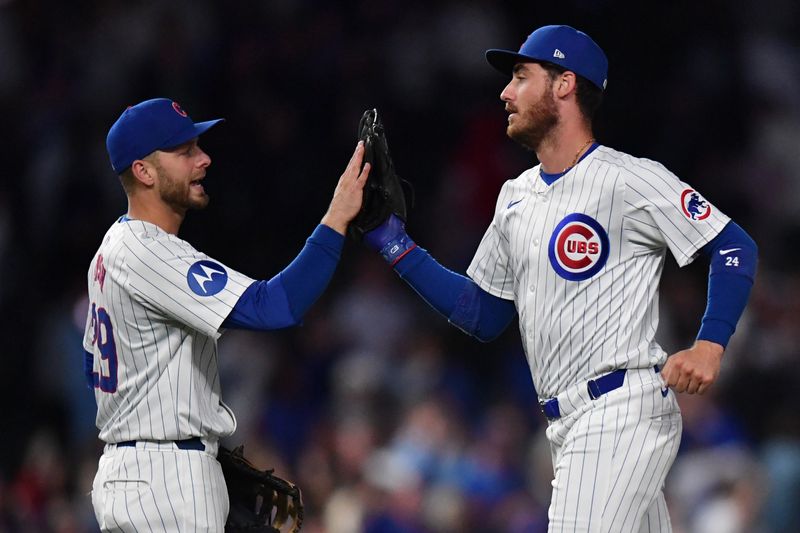 Aug 20, 2024; Chicago, Illinois, USA; Chicago Cubs first base Michael Busch (29) and right fielder Cody Bellinger (24) celebrate after defeating the Detroit Tigers at Wrigley Field. Mandatory Credit: Patrick Gorski-USA TODAY Sports