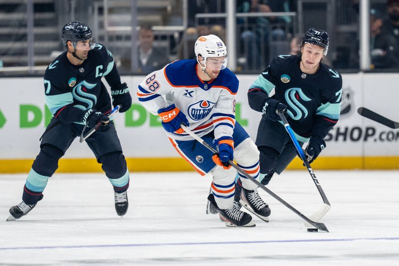 Oct 25, 2025; Seattle, Washington, USA; Edmonton Oilers forward Andrew Mangiapane (88) skates against Seattle Kraken forward Jordan Eberle (7), lef,t and forward Berkly Catton (77) during the first period at Climate Pledge Arena. Mandatory Credit: Stephen Brashear-Imagn Images