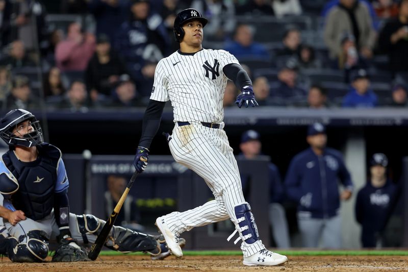 Apr 19, 2024; Bronx, New York, USA; New York Yankees right fielder Juan Soto (22) follows through on a three run home run against the Tampa Bay Rays during the seventh inning at Yankee Stadium. Mandatory Credit: Brad Penner-USA TODAY Sports