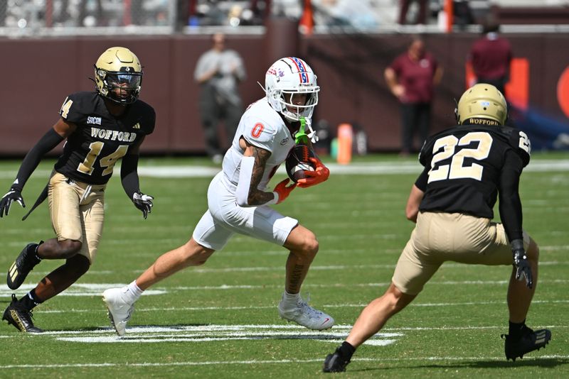 Sep 20, 2025; Blacksburg, Virginia, USA; Virginia Tech Hokies wide receiver Ayden Greene (0) runs after a catch as Wofford Terriers defensive back Darius Malcolm Jr. (14) and defensive back Perrin Ketchin (22) pursues during the third quarter at Lane Stadium. Mandatory Credit: Brian Bishop-Imagn Images