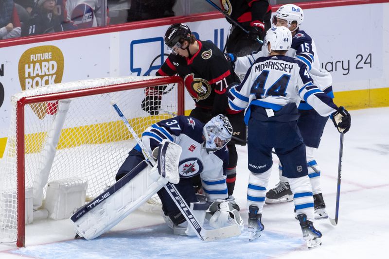 Jan 20, 2024; Ottawa, Ontario, CAN; Winnipeg Jets goalie Connor Hellebuyck (37) makes a save on a shot from Ottawa Senators center Ridly Greig (71) in the third period at the Canadian Tire Centre. Mandatory Credit: Marc DesRosiers-USA TODAY Sports