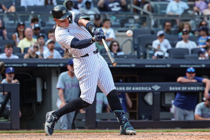 Aug 11, 2024; Bronx, New York, USA; New York Yankees center fielder Aaron Judge (99) hits a solo home run during the seventh inning against the Texas Rangers at Yankee Stadium. Mandatory Credit: Vincent Carchietta-USA TODAY Sports