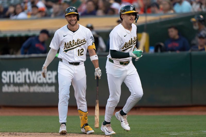 Jul 23, 2024; Oakland, California, USA;  Oakland Athletics shortstop Max Schuemann (12) and second base Zack Gelof (20) share a smile during the fourth inning against the Houston Astros at Oakland-Alameda County Coliseum. Mandatory Credit: Stan Szeto-USA TODAY Sports