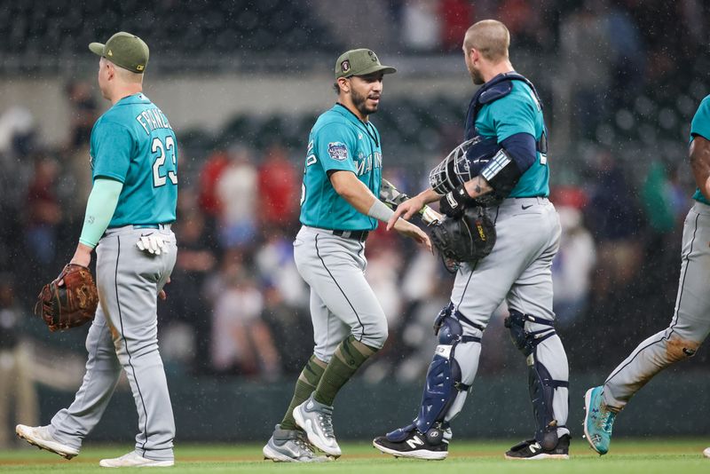 May 20, 2023; Atlanta, Georgia, USA; Seattle Mariners second baseman Jose Caballero (76) and catcher Tom Murphy (2) celebrate after a victory against the Atlanta Braves in at Truist Park. Mandatory Credit: Brett Davis-USA TODAY Sports