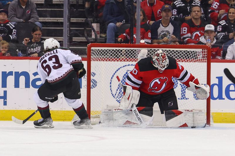 Oct 13, 2023; Newark, New Jersey, USA; New Jersey Devils goaltender Akira Schmid (40) makes a save on Arizona Coyotes left wing Matias Maccelli (63) during the second period at Prudential Center. Mandatory Credit: Ed Mulholland-USA TODAY Sports