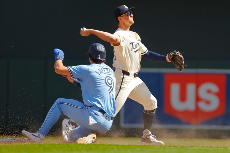 Sep 1, 2024; Minneapolis, Minnesota, USA; Minnesota Twins second baseman Brooks Lee (72) forces out Toronto Blue Jays center fielder Joey Loperfido (9) but cannot complete the double play in time in the seventh inning at Target Field. Mandatory Credit: Bruce Kluckhohn-USA TODAY Sports