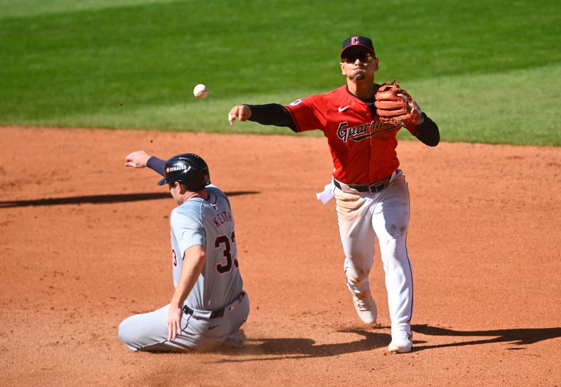 Oct 5, 2024; Cleveland, Ohio, USA; Cleveland Guardians second baseman Andres Gimenez (0) turns a double play over Detroit Tigers second baseman Colt Keith (33) in the fourth inning in game one of the ALDS for the 2024 MLB Playoffs at Progressive Field. Mandatory Credit: David Richard-Imagn Images