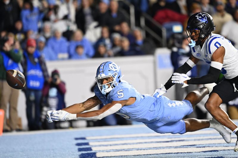 Nov 11, 2023; Chapel Hill, North Carolina, USA; North Carolina Tar Heels wide receiver J.J. Jones (5) attempts to catch the Ball as Duke Blue Devils cornerback Chandler Rivers (0) defends in the fourth quarter at Kenan Memorial Stadium. Mandatory Credit: Bob Donnan-USA TODAY Sports