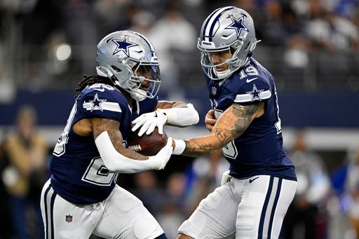 Dallas Cowboys running back Rico Dowdle (23) takes the ball from quarterback Trey Lance (19) during an NFL football game against the Washington Commanders in Arlington, Texas, Sunday, Jan. 5, 2025. (AP Photo/Jerome Miron)