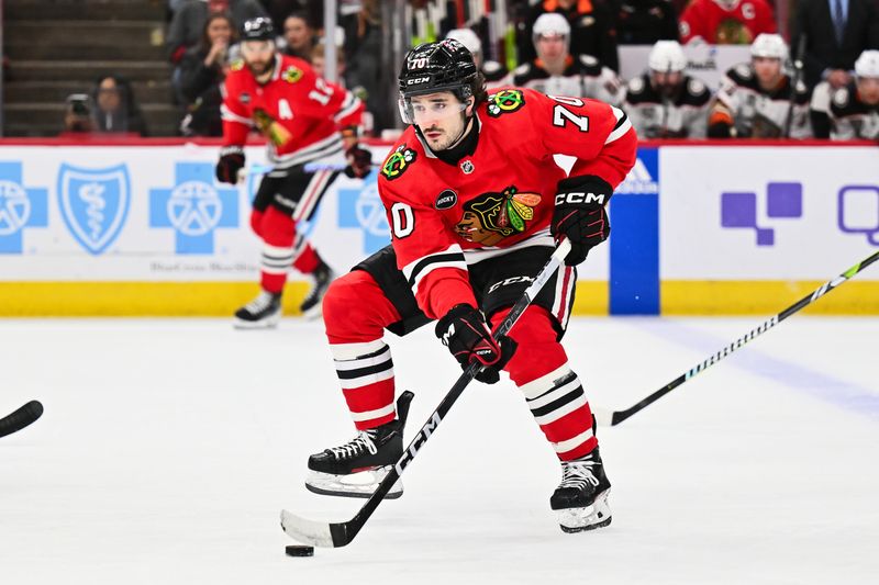 Dec 7, 2023; Chicago, Illinois, USA; Chicago Blackhawks forward Cole Guttman (70) skates the puck in to the offensive zone in the first period against the Anaheim Ducks at United Center. Mandatory Credit: Jamie Sabau-USA TODAY Sports