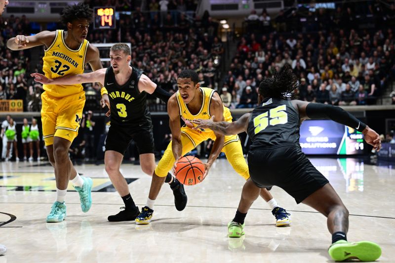 Jan 23, 2024; West Lafayette, Indiana, USA; Michigan Wolverines guard Nimari Burnett (4) grabs a ball from between Purdue Boilermakers guard Braden Smith (3) and guard Lance Jones (55) during the first half at Mackey Arena. Mandatory Credit: Marc Lebryk-USA TODAY Sports