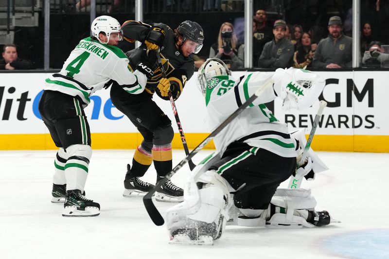 Jan 28, 2025; Las Vegas, Nevada, USA; The stick of Dallas Stars defenseman Miro Heiskanen (4) is loose as goaltender Jake Oettinger (29) makes a save against Vegas Golden Knights right wing Jonas Rondbjerg (46) during the second period at T-Mobile Arena. Mandatory Credit: Stephen R. Sylvanie-Imagn Images