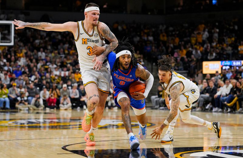 Jan 3, 2026; Columbia, Missouri, USA; Florida Gators guard Boogie Fland (0) drives against Missouri Tigers guard Jacob Crews (35) and guard Jayden Stone (17) during the second half at Mizzou Arena. Mandatory Credit: Jay Biggerstaff-Imagn Images