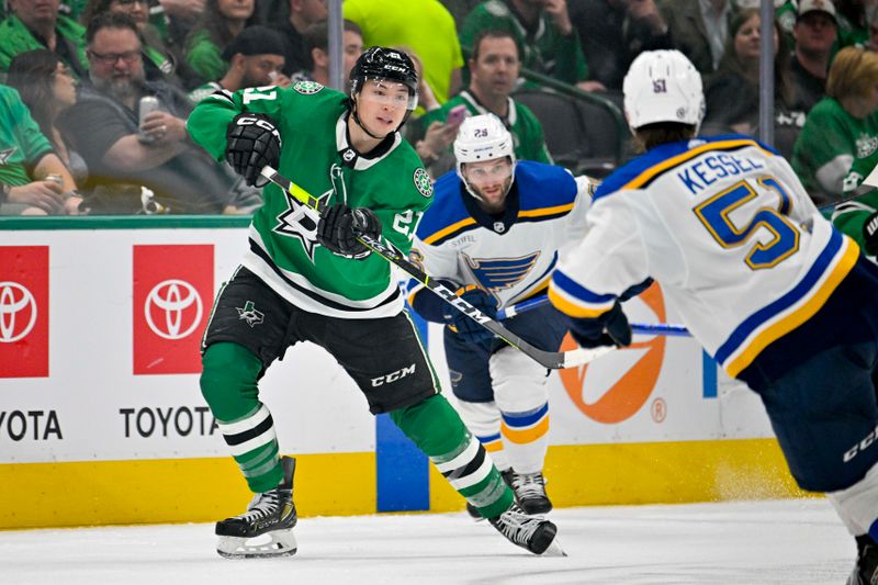 Apr 17, 2024; Dallas, Texas, USA; Dallas Stars left wing Jason Robertson (21) passes the puck by St. Louis Blues defenseman Matthew Kessel (51) during the second period at the American Airlines Center. Mandatory Credit: Jerome Miron-USA TODAY Sports