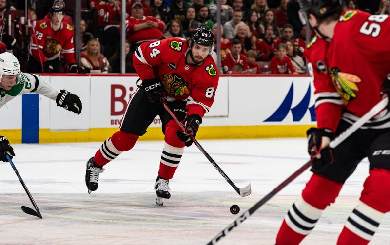 Apr 6, 2024; Chicago, Illinois, USA; Chicago Blackhawks left winger Landon Slaggert (84) keeps the puck away from Dallas Stars defenseman Esa Lindell (23) during the third period at United Center. Mandatory Credit: Seeger Gray-USA TODAY Sports