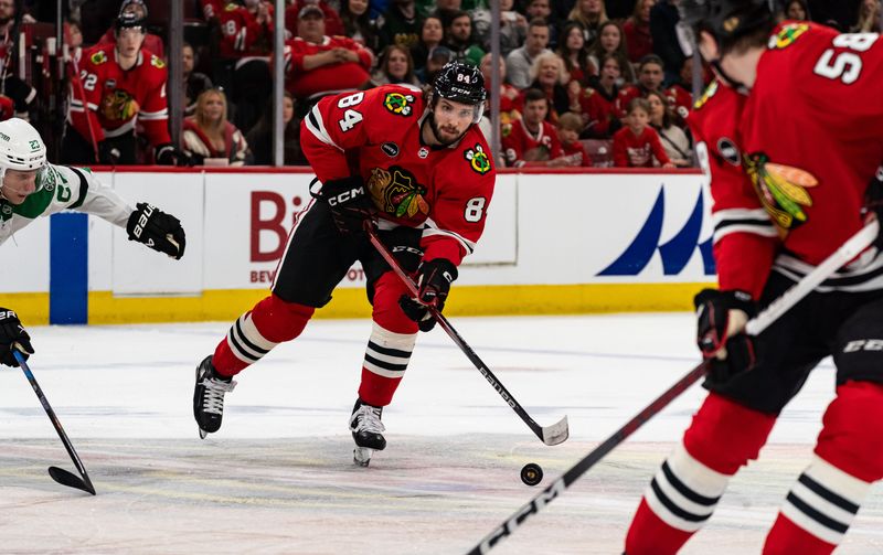 Apr 6, 2024; Chicago, Illinois, USA; Chicago Blackhawks left winger Landon Slaggert (84) keeps the puck away from Dallas Stars defenseman Esa Lindell (23) during the third period at United Center. Mandatory Credit: Seeger Gray-USA TODAY Sports