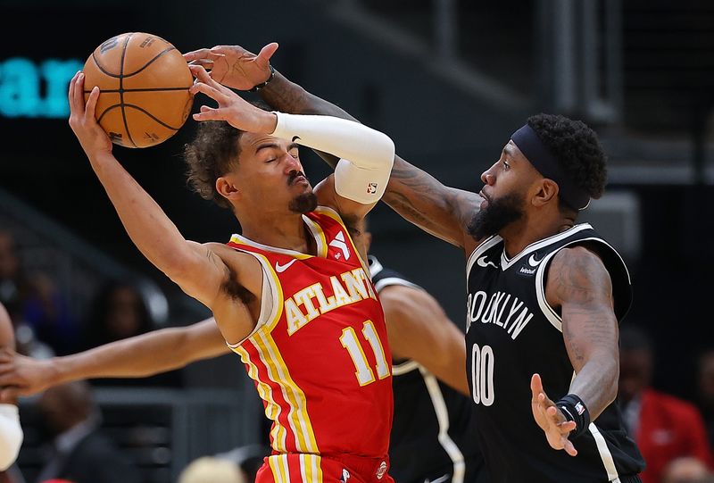 ATLANTA, GEORGIA - DECEMBER 06:  Mikal Bridges #1 of the Brooklyn Nets drives between Onyeka Okongwu #17 and Bogdan Bogdanovic #13 of the Atlanta Hawks during the third quarter at State Farm Arena on December 06, 2023 in Atlanta, Georgia.  NOTE TO USER: User expressly acknowledges and agrees that, by downloading and/or using this photograph, user is consenting to the terms and conditions of the Getty Images License Agreement.  (Photo by Kevin C. Cox/Getty Images)