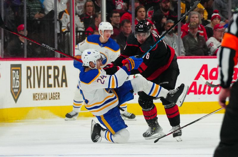 Dec 2, 2023; Raleigh, North Carolina, USA; Carolina Hurricanes defenseman Brady Skjei (76) checks Buffalo Sabres center Dylan Cozens (24) during the third period at PNC Arena. Mandatory Credit: James Guillory-USA TODAY Sports